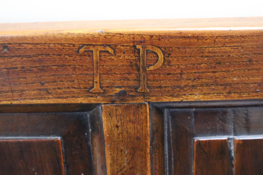 An 18th century oak panel back open armchair with wood seat,